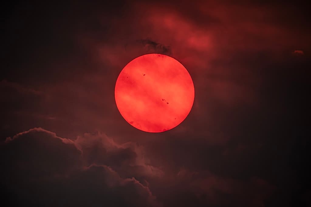 NASA obrázek dne: Červené slunce skrz kouř z lesních požárů